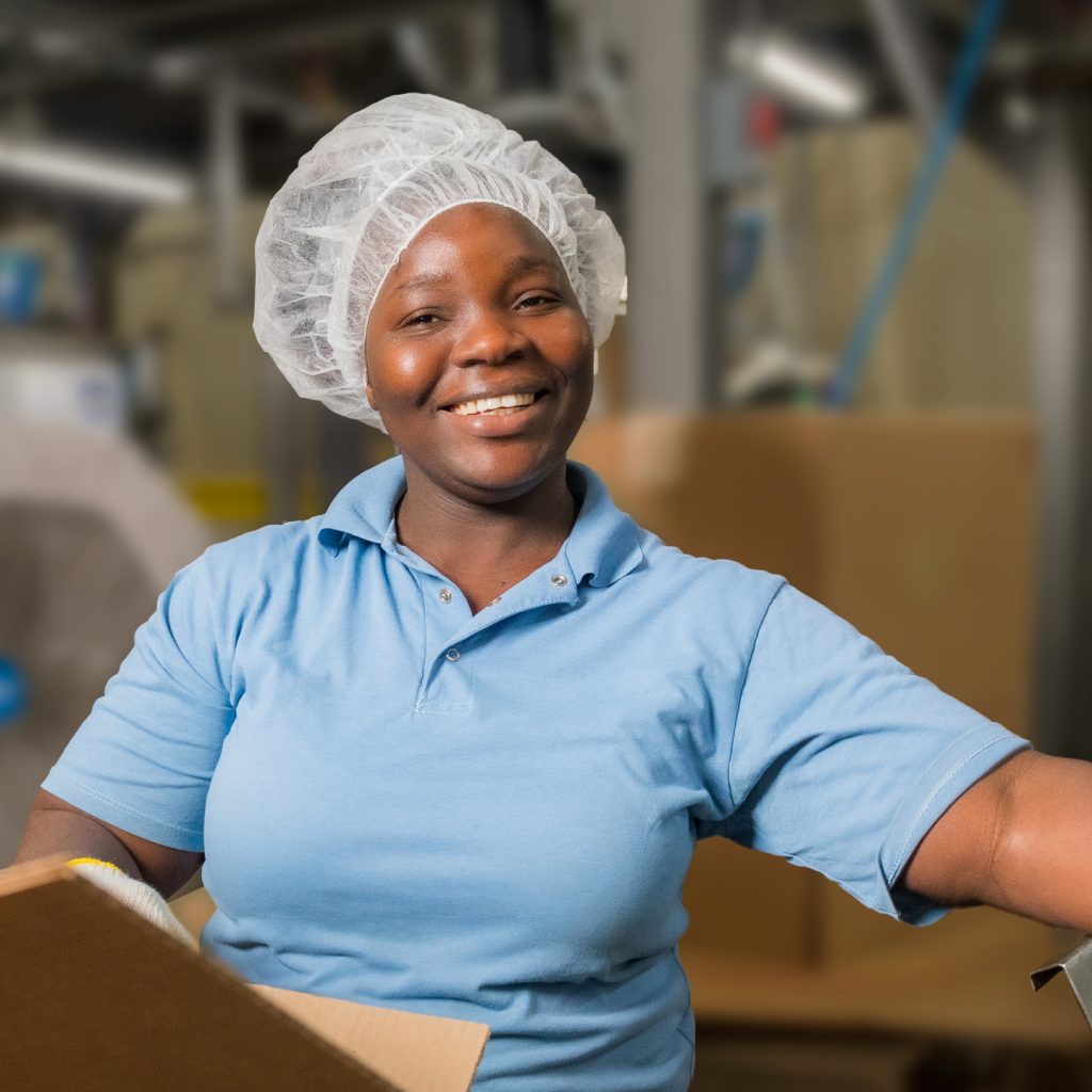Happy employee wearing a hair net and blue shirt